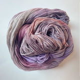 Lilac hand dyed sock yarn in variegated shades of lavender, pink, peach, blue, and purple.