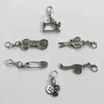 locking stitch marker charms include a sewing machine, yarn hank, scissors, safety pin, measuring tape, and buttons