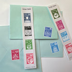 Postage stamp shaped stickers with cozy cut paper folk artwork