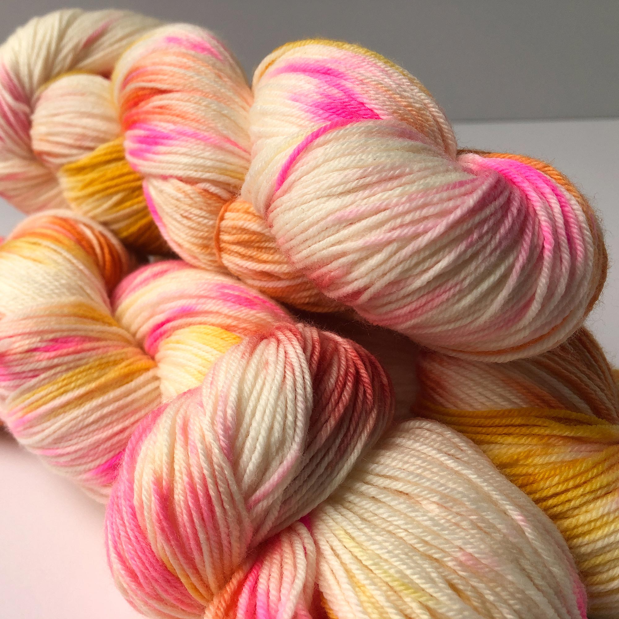 pink, peach, orange, yellow, speckled merino yarn