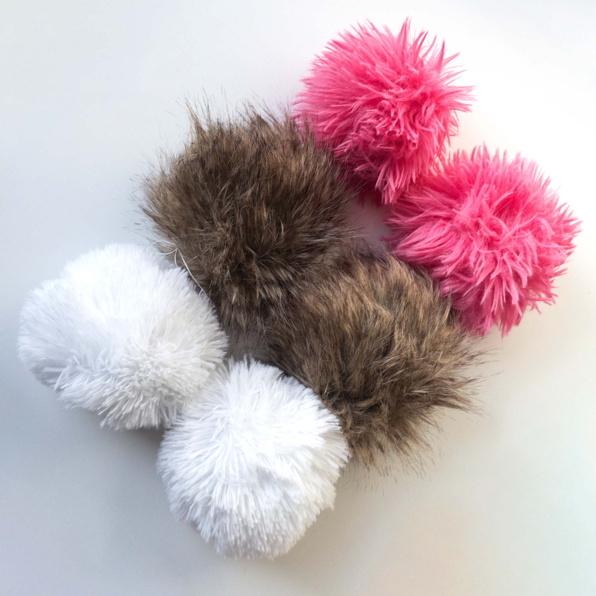 Six faux fur pompoms in three colors: fuschia pink, white, and rabbit fur brindle