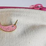 Narwhal enamel pin on a zipper pouch