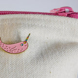 Narwhal enamel pin on a zipper pouch