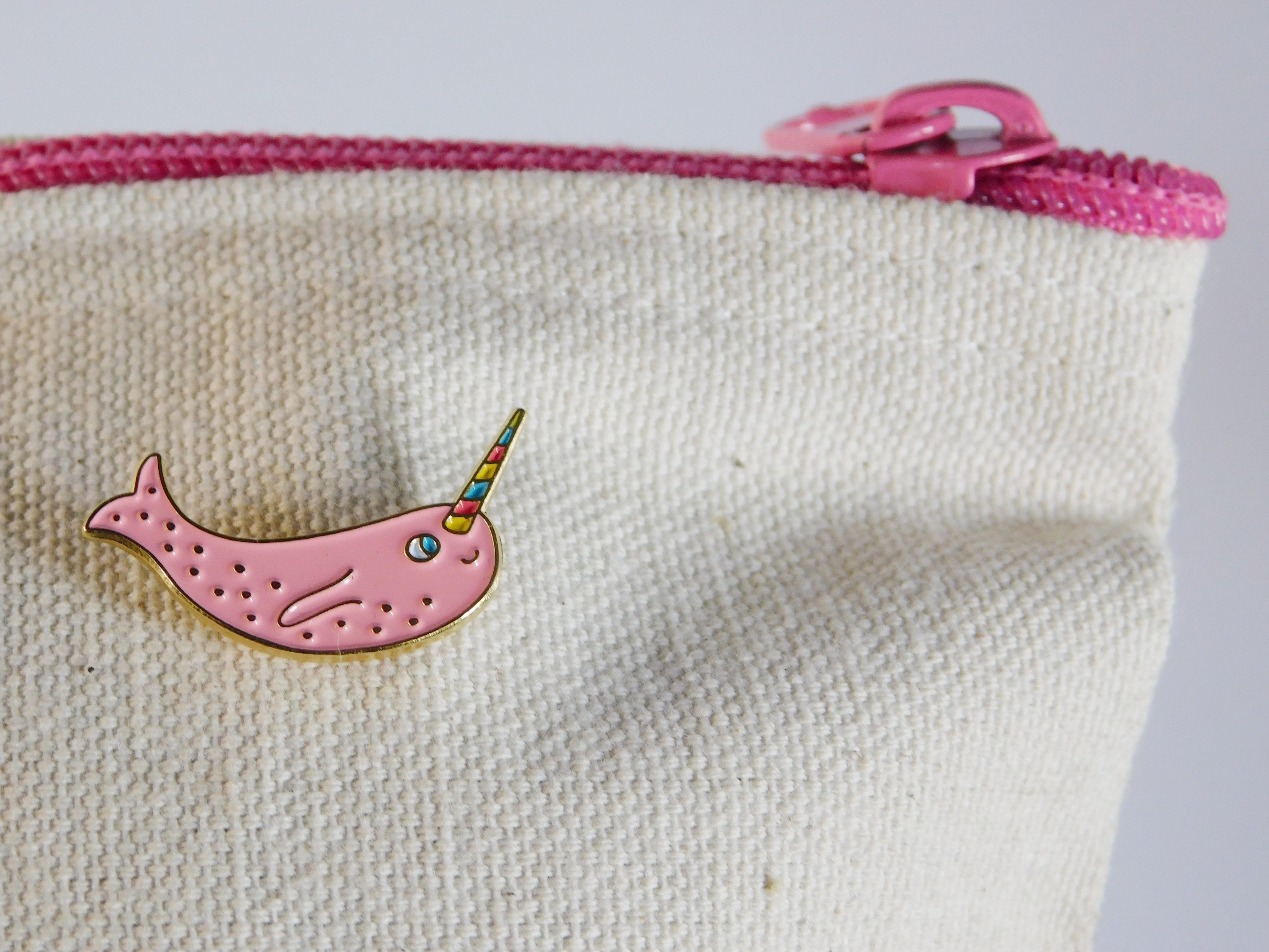 Narwhal enamel pin on a zipper pouch