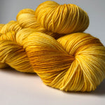 hand-dyed in tones of gold and yellow fingering weight yarn