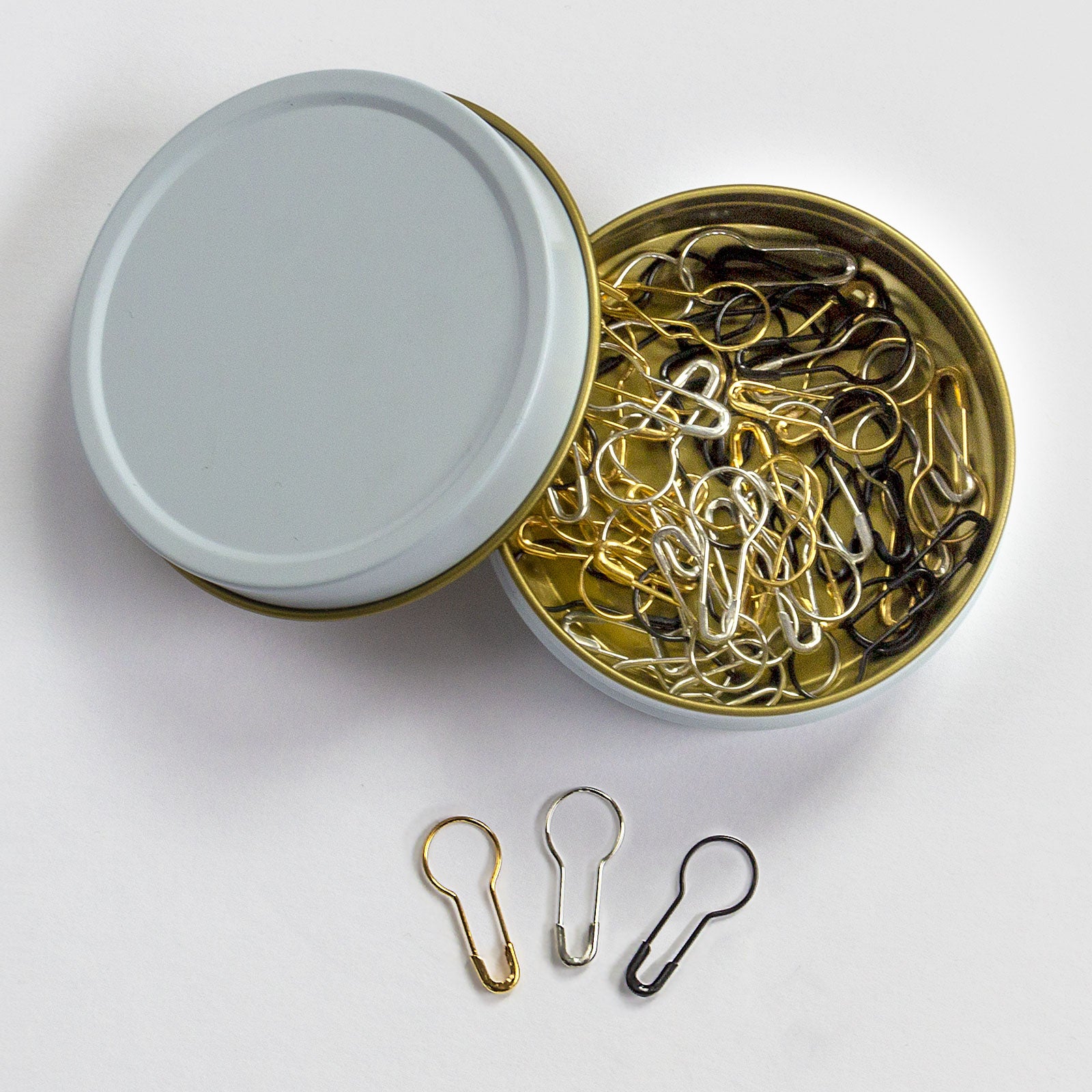 removable pear-shaped metal stitch marker set in a white and gold storage case