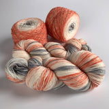 space dyed coral and gray sock yarn twisted hanks and caked center pull balls
