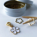 set of 12 gold flower stitch markers with one progress keeper charm